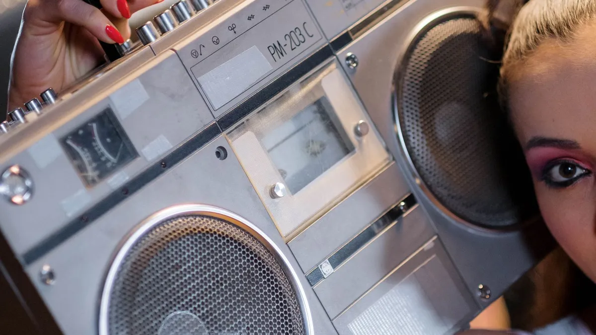A person in retro style holding a vintage boombox