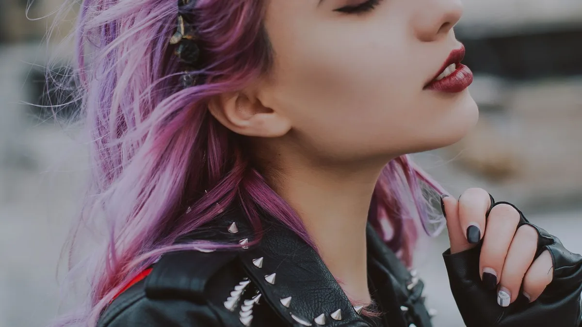 A woman with pink dyed hair in a leather jacket