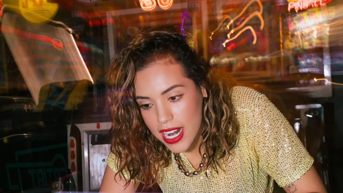 A face lit by vivid neon colour in an arcade