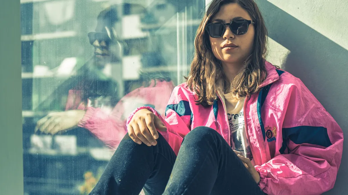 Portrait of a person in a bright 1980s colour-blocked jacket