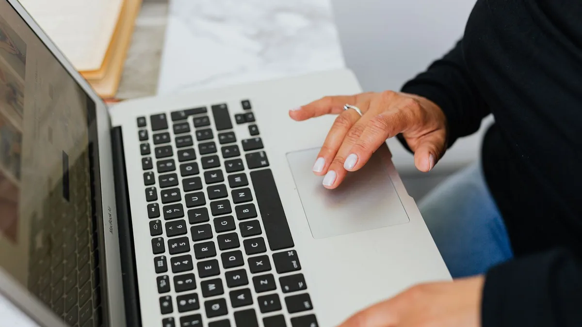 Close-up of hands typing on a laptop keyboard